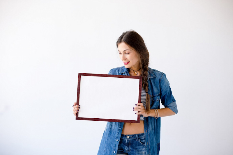 girl holding blank graduation frame