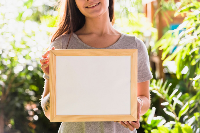 girl holding blank graduation frame